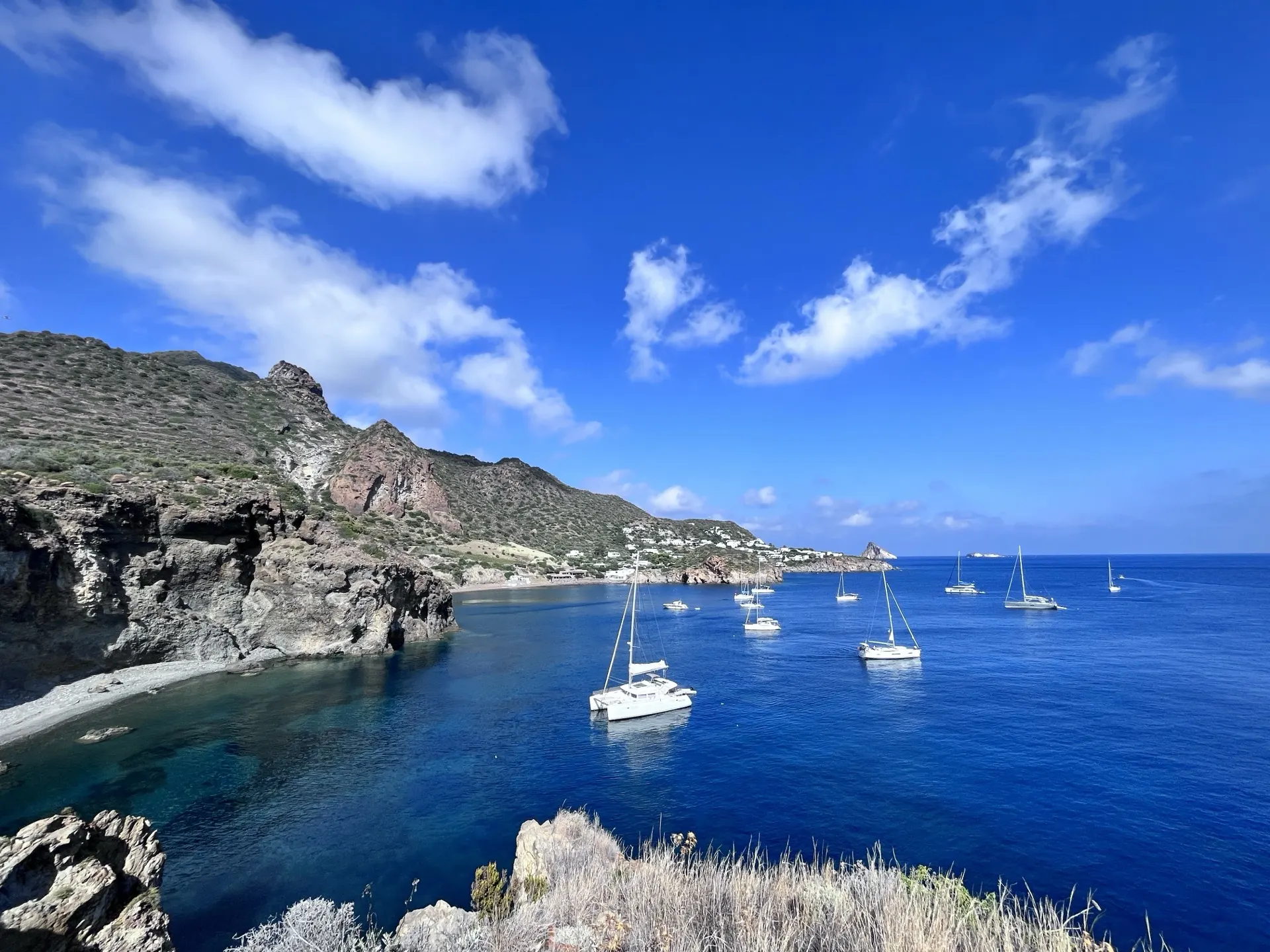 Flotilă de veliere și catamarane ancorate în golf — worldwide charter TOA Retreat